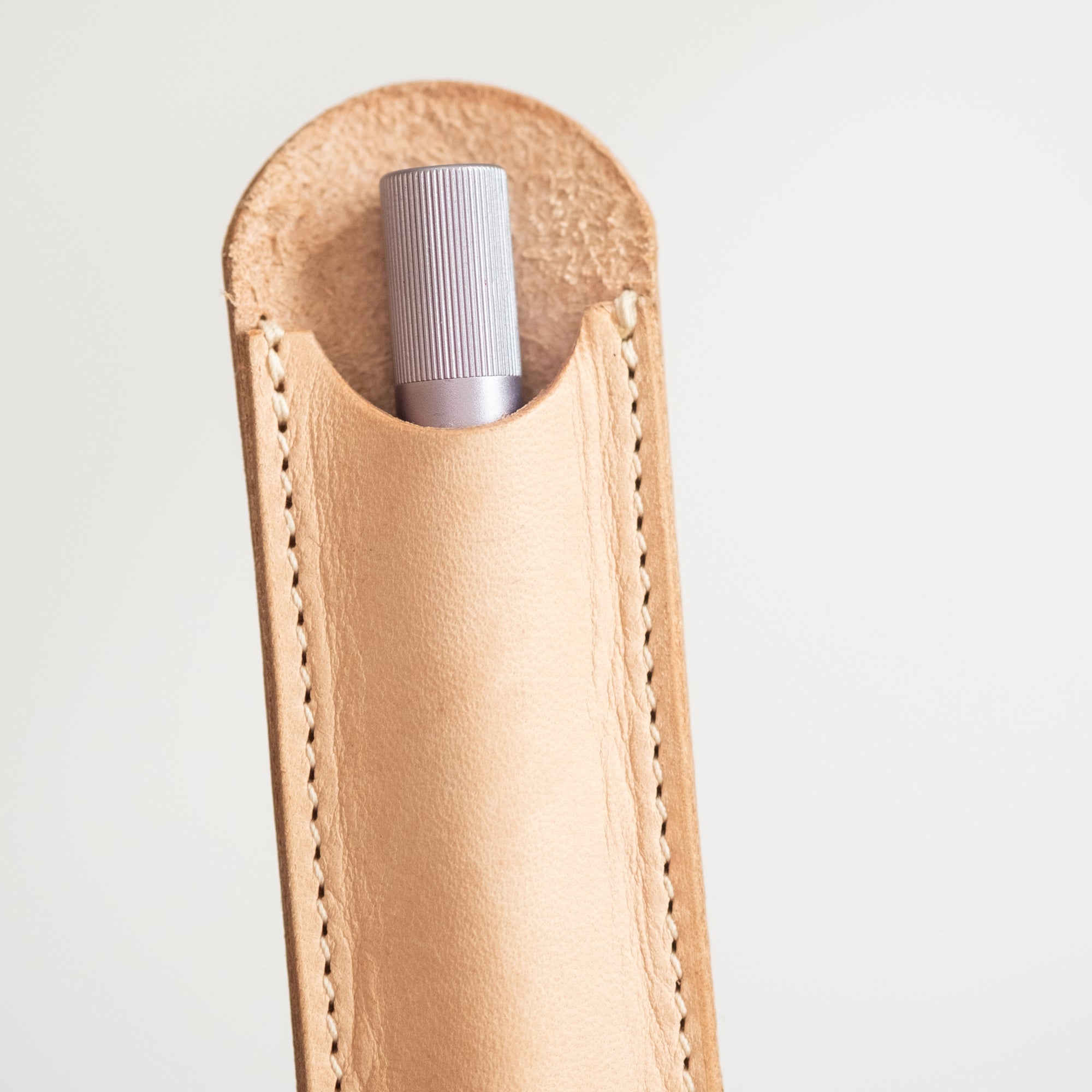 Detail shot of the leather Pen Sleeve for the Lumos Pro in Natural, with the Lumos Pro in Lilac