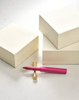 Three MD Memo Blocks – plain, ruled and grid, with the Wren refillable writing pen in Raspberry on a Brass Butterfly Pen Rest.