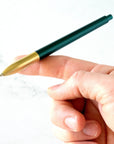 The Tom's Studio Mechanical Pencil in Ivy, balanced on an outstretched finger