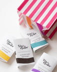 A selection of Tom's Studio Mini Fountain Pen Inks packaged in a candy-stripe paper bag