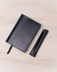 Leather Pen Sleeve for the Lumos Pro in Black shown with matching leather notebook cover and the Studio Fountain Pen in Black