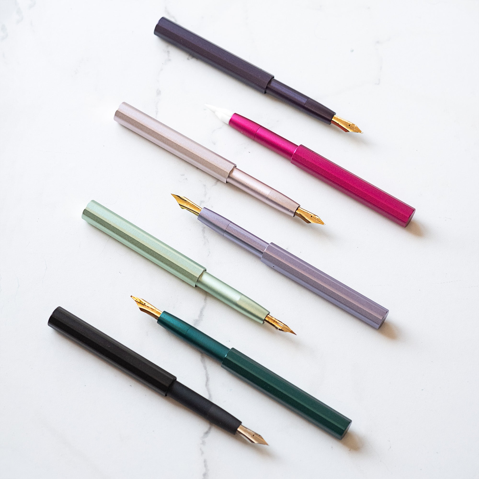 The Pocket Fountain Pen shown in various colours and with a selection of fountain pen nibs