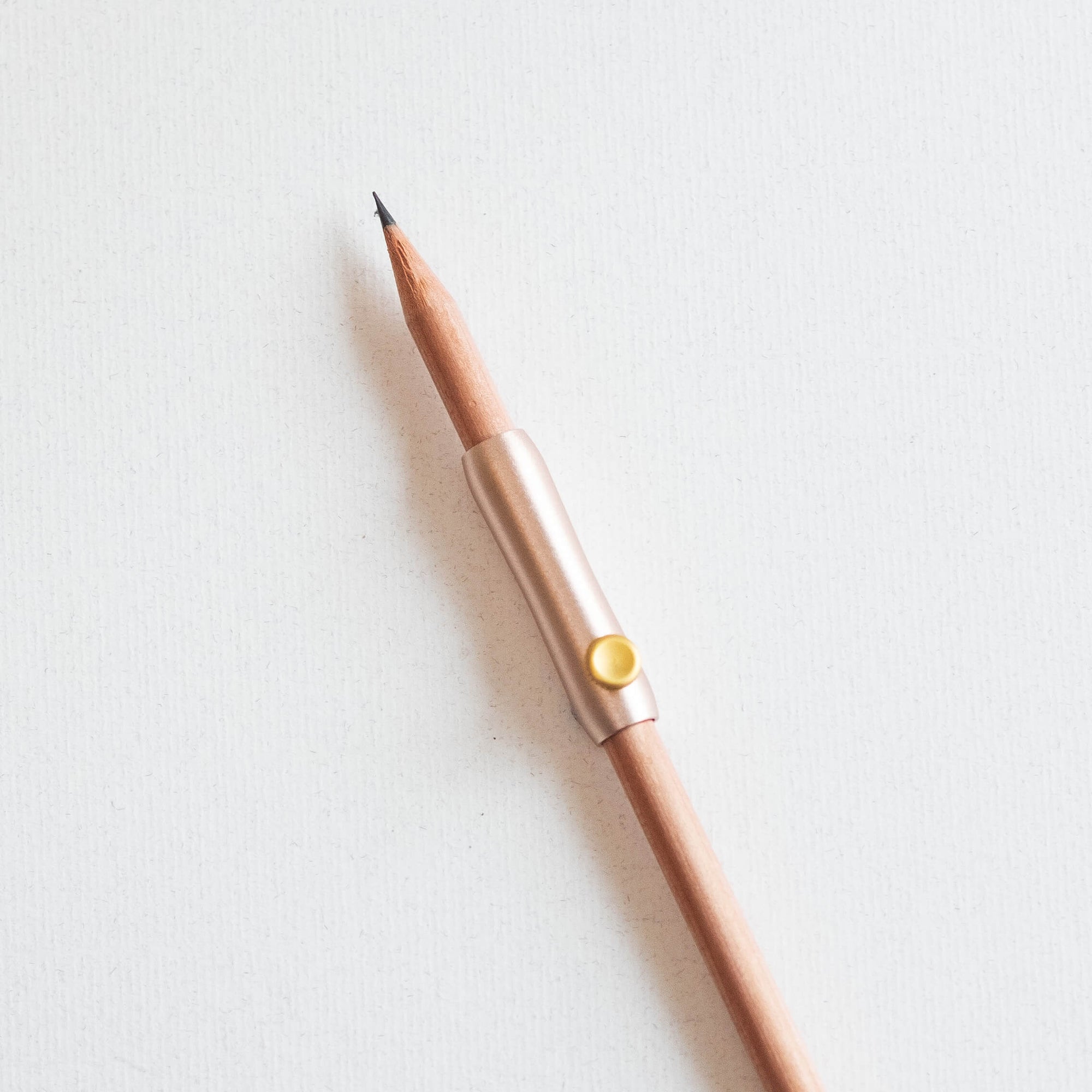 The Poise Pencil Grip Extender in Blush shown on a standard pencil.