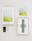 The Wren refillable everyday writing pen in Sage shown with the packaging – contents includes instruction book, 3ml fibre tip ink sample, ink reservoir and writing tip