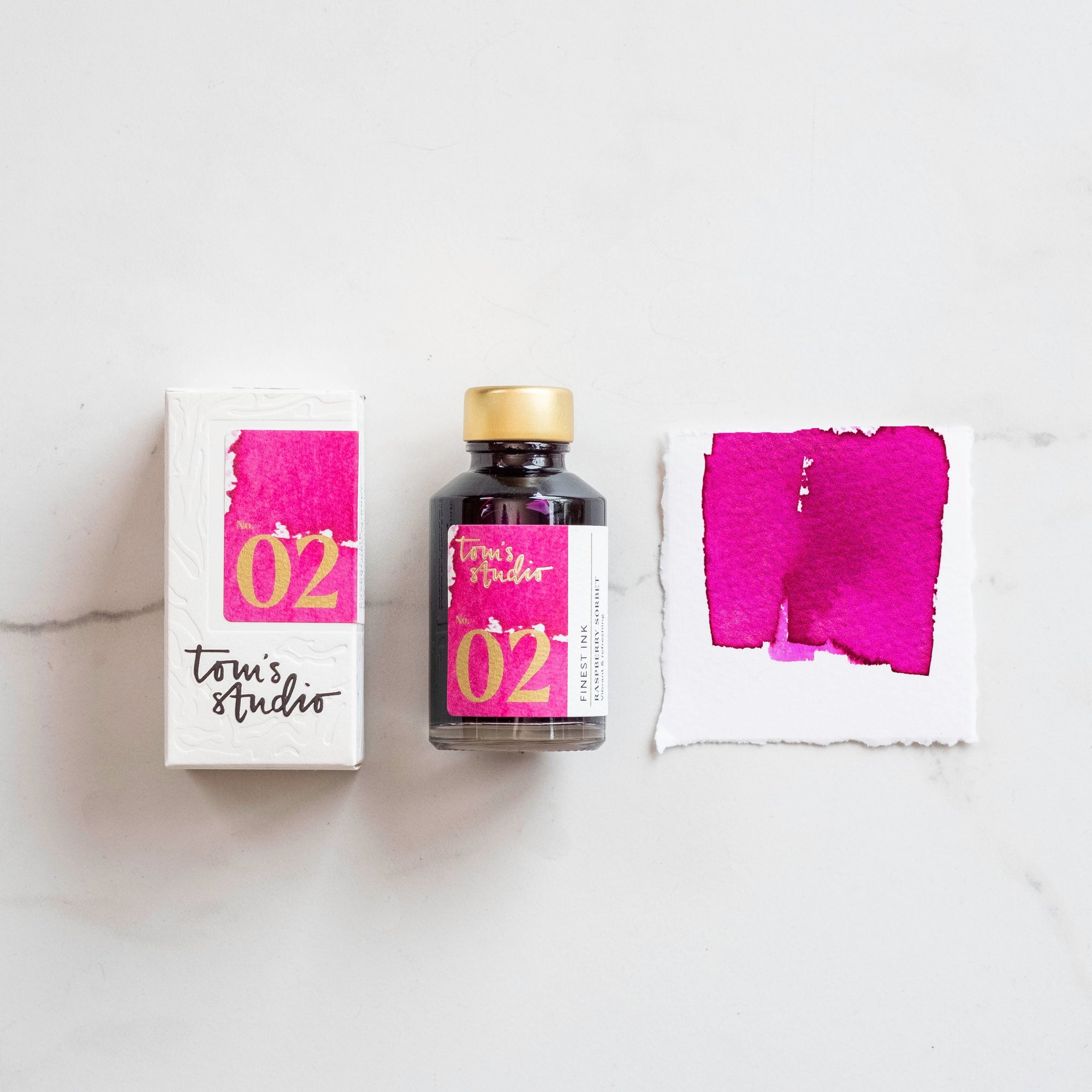 Tom&#39;s Studio Raspberry Sorbet Fountain Pen Ink with two pens with inky goodness on paper with an ink swatch demonstrating the colour
