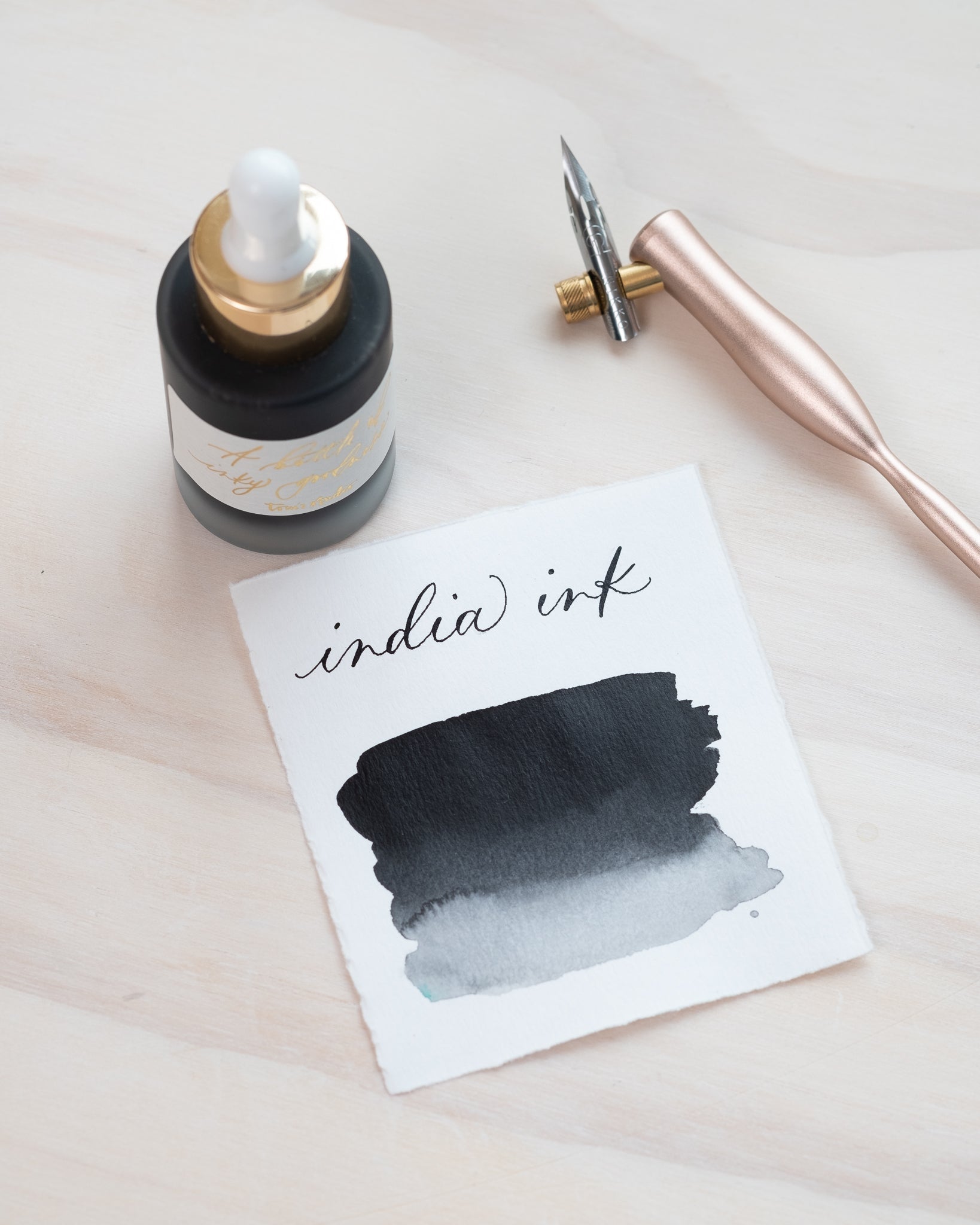 Black India Ink in bottle with swatch showing the ink colour