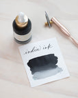 Black India Ink in bottle with swatch showing the ink colour
