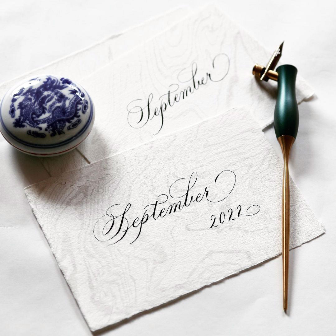 The Bloom calligraphy pen in Ivy with oblique nib setting shown with an example of calligraphy lettering