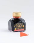 A bottle of Coral fountain pen ink from Diamine on a white background