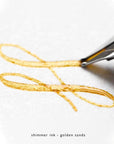 A flourish of gold shimmer ink written with a fountain pen
