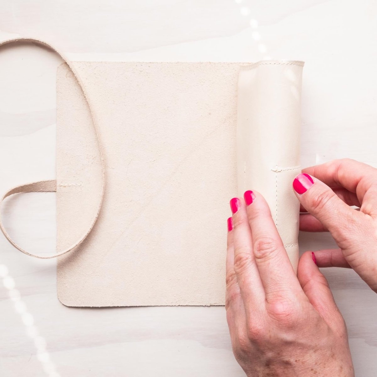 A person rolling the handmade leather pen roll