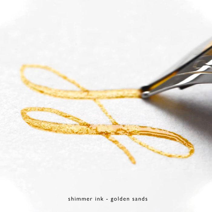 a flourish of gold shimmer fountain pen ink written with a fountain pen
