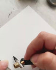 Demonstration of an oblique calligraphy pen writing the word flourish in black ink