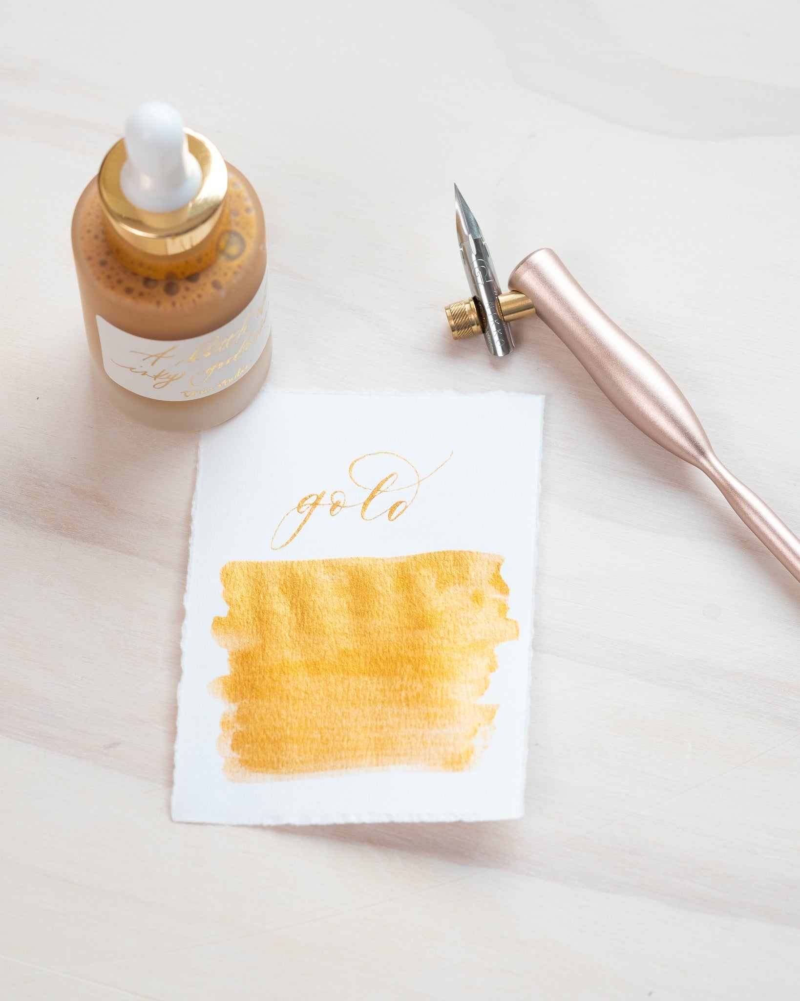Gold - Calligraphy Ink in bottle with swatch showing the ink colour