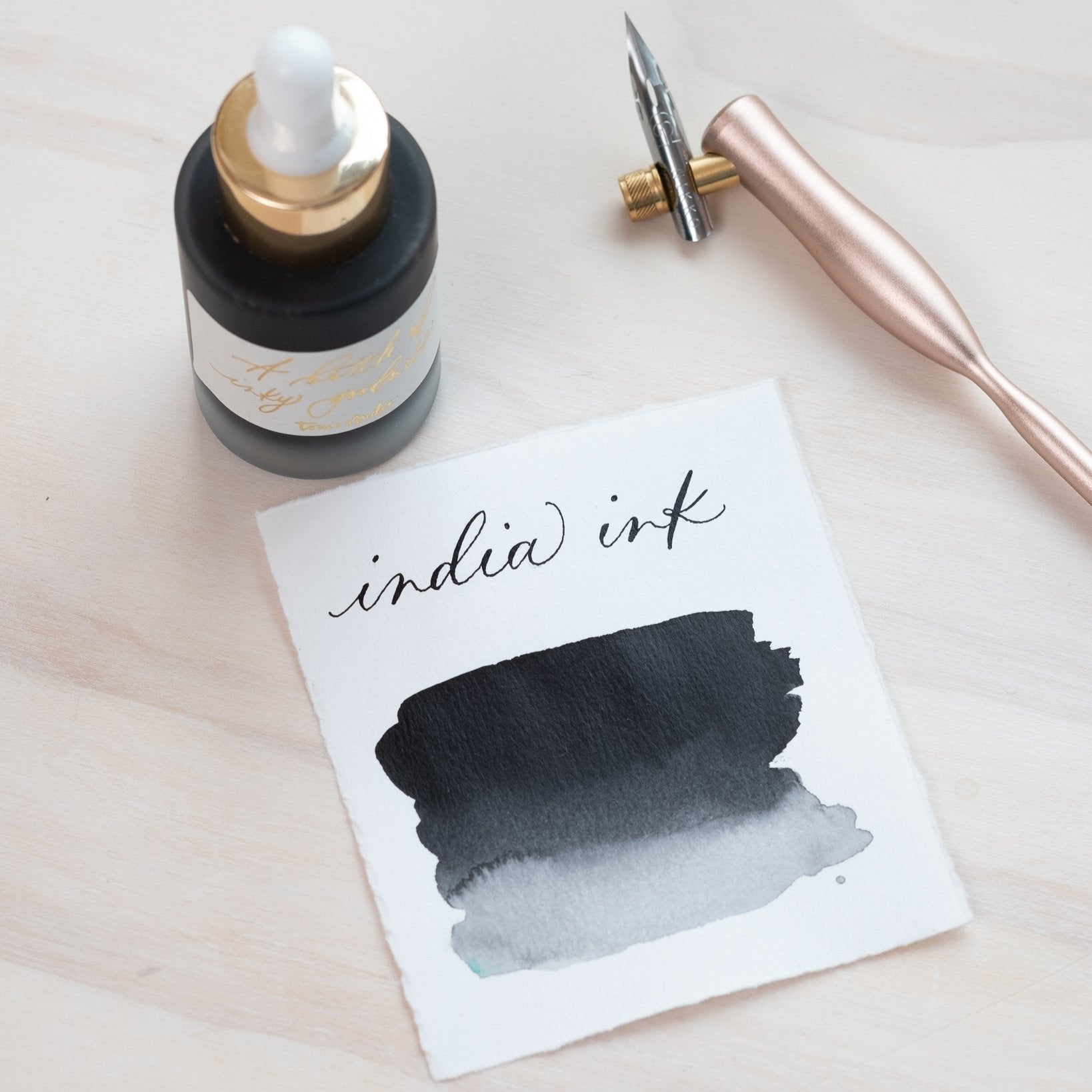 Black India Ink in bottle with swatch showing the ink colour