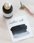 Black India Ink in bottle with swatch showing the ink colour