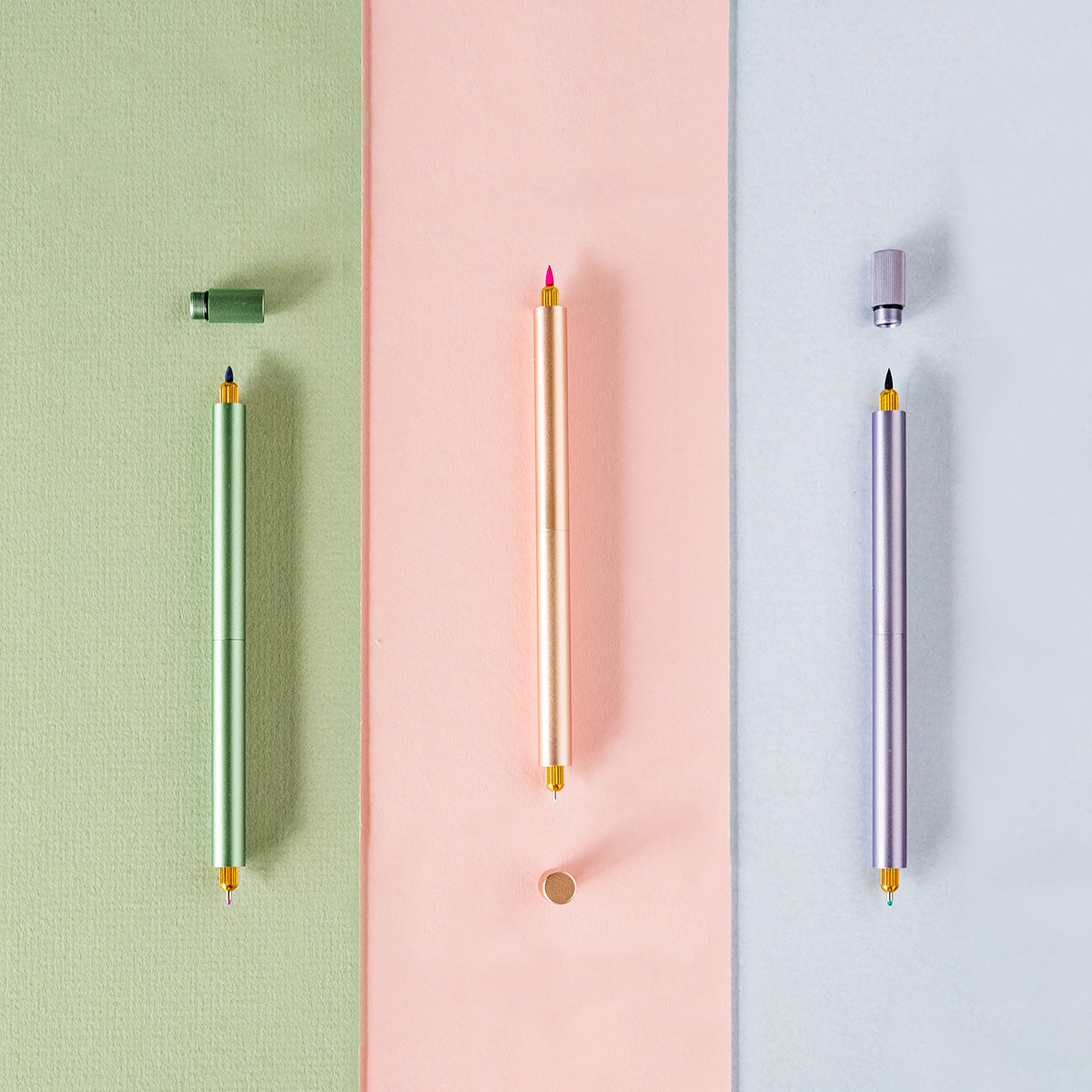 The Lumos Pro Duo Refillable Pen in three colours (left to right) Sage, Blush, Lilac with fineliner and brush tips