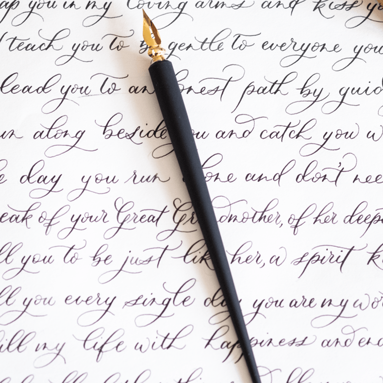 The Original Flourish Straight Calligraphy Pen in Black shown on a page of calligraphy