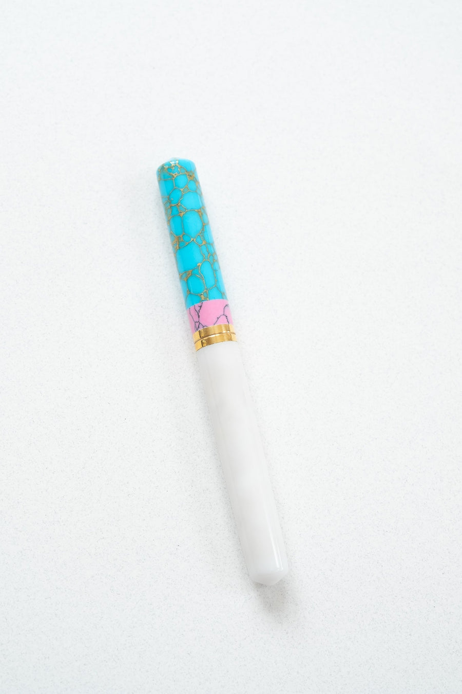 Pink + Turquoise Studio Fountain Pen closed on a white desk