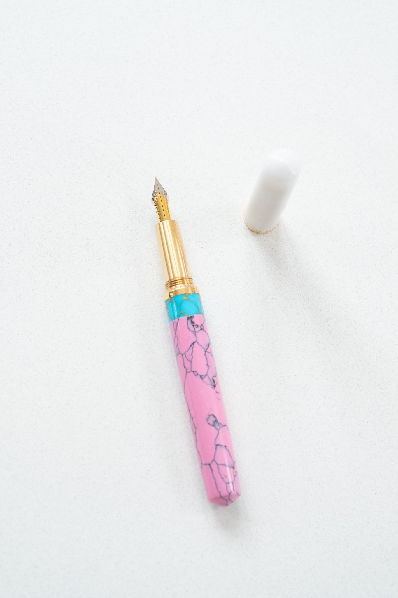 Pink + Turquoise - Studio Fountain pen on a white desk open showing the flexible fountain pen nib