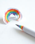 Rainbow pencil close up with a sharpened lead and a wood shaving fro the pencil showing the rainbow