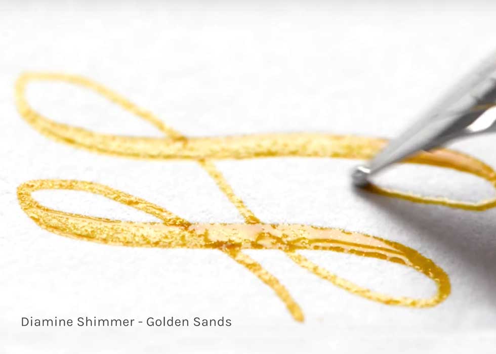 Shimmering Seas - Shimmer Fountain Pen Ink a pen writing in golden sands ink