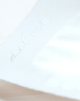 Silver calligraphy writing on a sheet of paper